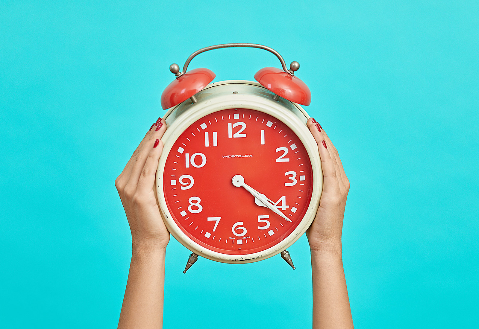 red westclox clock against turquoise background