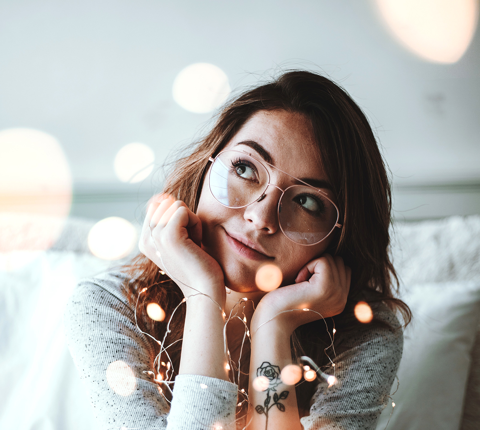 Young woman with tattoo looking to her right and thinking about dreams